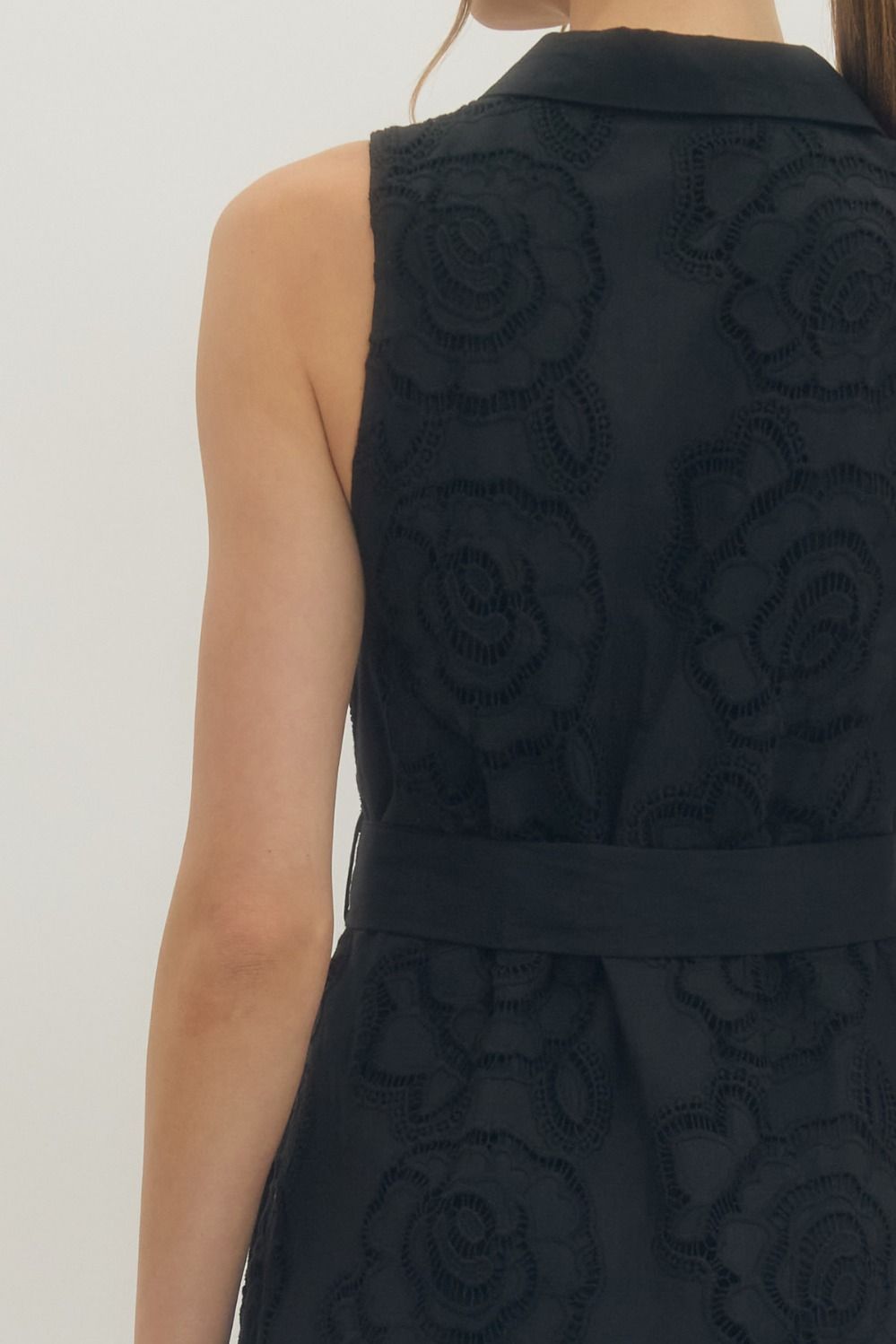 Solid sleeveless mini dress featuring floral lace overlay and self-tie belt at waist