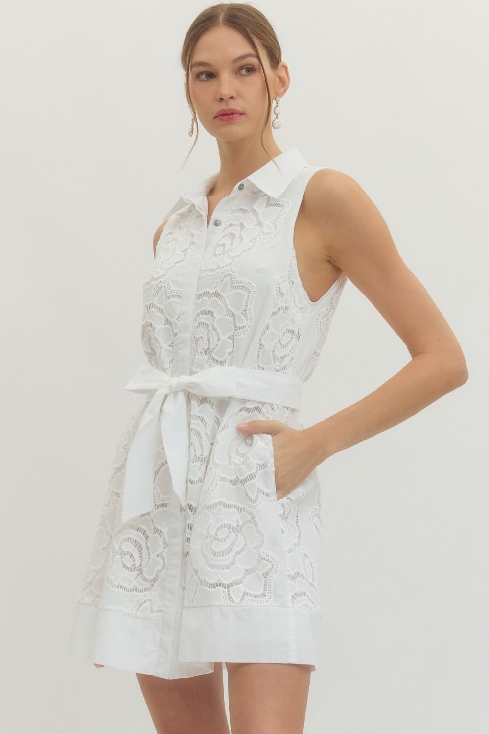Solid sleeveless mini dress featuring floral lace overlay and self-tie belt at waist
