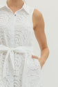 Solid sleeveless mini dress featuring floral lace overlay and self-tie belt at waist